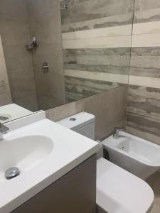 a bathroom with a toilet and a sink and a shower at Punta Carretas Vista al Mar in Montevideo