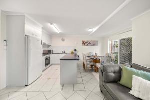 a kitchen and living room with a couch and a table at Sunshine Hideaway - Easy Beachside Living in Mooloolaba +19 photos
