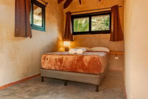 a bedroom with a bed in a room with two windows at Manta Project in Morrillo +40 photos