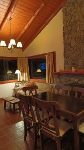 a dining room with a table and a couch at Aldea Aliwen in Trevelín