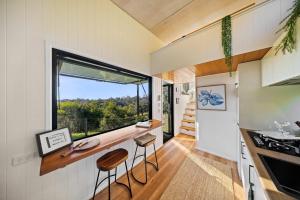a small kitchen with a counter and a window at Lily Pad Tiny Home in Maleny