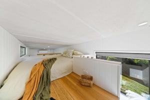 a bedroom with a bed and a large window at Lily Pad Tiny Home in Maleny