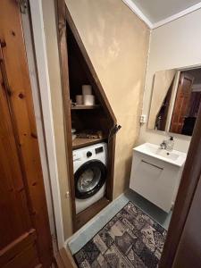 a small bathroom with a washing machine and a sink at Old farm house & sauna in Stunes +28 photos