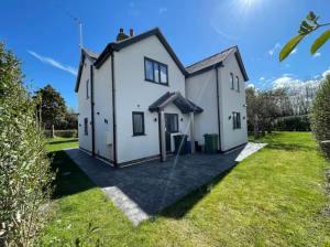 a large white house with a large yard at The Farmhouse at Moss Bank Farm in Wrexham