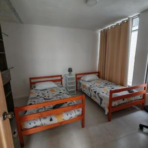 a bedroom with two beds and a window at Apartamentos Las Orquideas in San Pedro +9 photos