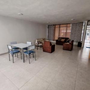 a living room with a table and chairs and a couch at Apartamentos Las Orquideas in San Pedro