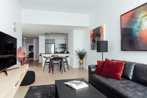 a living room with a black couch and a table at Mint House 70 Pine by Kasa in New York