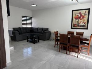 a living room with a couch and a table and chairs at Modern House with Mini-Splits in Chihuahua