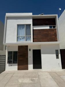 a white house with two doors and a window at Modern House with Mini-Splits in Chihuahua
