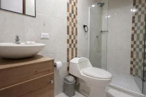 a bathroom with a toilet and a sink and a shower at Hotel Getsemaní Central in Cartagena de Indias