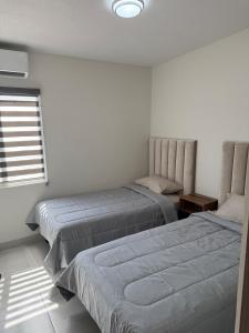 a bedroom with two beds and a window at Modern House with Mini-Splits in Chihuahua