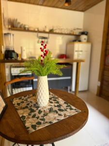 a vase with flowers on a table in a kitchen at Cabana Pouso Sereno in Domingos Martins