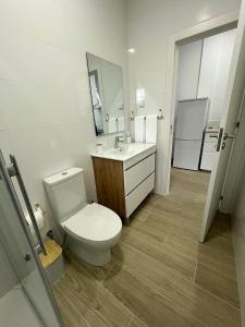 a white bathroom with a toilet and a sink at Cozy Noia in Machico +20 photos