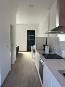 a kitchen with white cabinets and a counter top at Cozy Noia in Machico