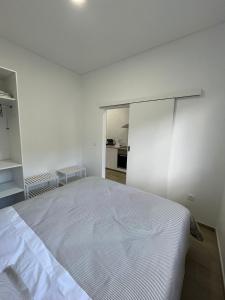 a white bedroom with a large bed in it at Cozy Noia in Machico