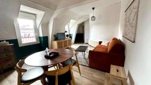 a living room with a table and a couch at Villa Hyper Centre Le Blanc Type Hotel Entrée Autonome Spa et Nuit en brenne in Le Blanc