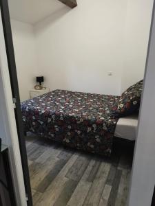 a small bedroom with a bed with a flowered blanket at les lauriers in Saint-Sernin