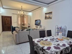 a living room with a table and a couch at Appartement moderne 2 chambres Grand-Bassam, Pharmacie Yélé in Moosou