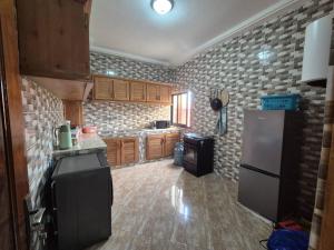 a kitchen with a refrigerator and a counter top at Appartement moderne 2 chambres Grand-Bassam, Pharmacie Yélé in Moosou
