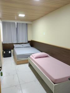 a bedroom with two beds in a room at EL Shaday in Guarujá
