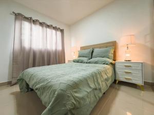 a bedroom with a bed and a dresser and a window at Relaxing & New Retreat 3 bedroom riviera Verde in Santo Domingo