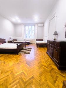 a large room with two beds and a dresser at Downtown apartment in walk zone with 3 bedrooms and garage in Novi Sad