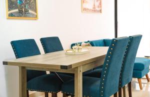 a dining room table and chairs with blue chairs at Relaxing & New Retreat 3 bedroom riviera Verde in Santo Domingo +17 photos