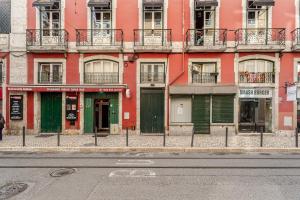 a red building on the side of a street at Cais Sodré Spacious Apartment in Lisbon