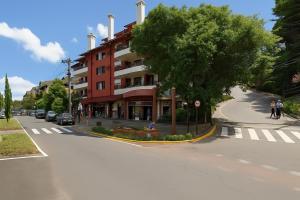 a building on the side of a street with a tree at Casa For Rua Torta in Gramado