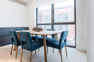 a dining room with a wooden table and blue chairs at Alpine Living - Modern 2 Bedroom Condo in Revelstoke