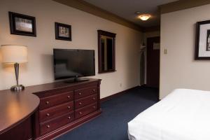 a bedroom with a bed and a television on a dresser at Le Deville par G5 in Rouyn-Noranda +15 photos
