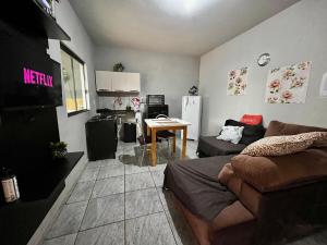 a living room with a couch and a kitchen at Loft B - individual Mobiliado com Ar-condicionado in Dourados