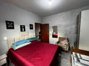 a bedroom with a red bed and a chair at Loft B - individual Mobiliado com Ar-condicionado in Dourados