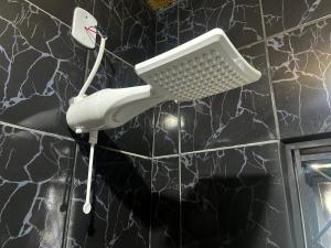 a bathroom with a white phone on a black wall at Loft B - individual Mobiliado com Ar-condicionado in Dourados +15 photos