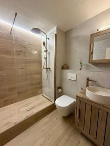 a bathroom with a shower and a toilet and a sink at HappyLaax - Panoramic Penthouse - Pool, Sauna & Private Parking in Laax