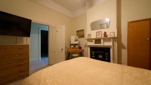 a bedroom with a bed with a television and a fireplace at Squatters Cottage in Port Augusta