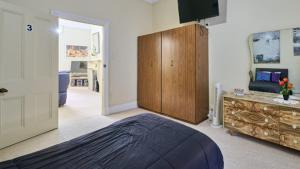 a bedroom with a large bed and a wooden cabinet at Squatters Cottage in Port Augusta +3 photos
