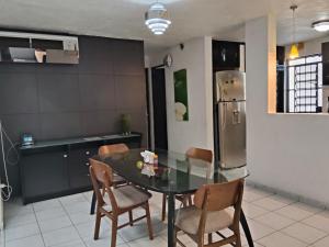 a kitchen with a table and chairs and a refrigerator at Casa pame 2026 in Mérida