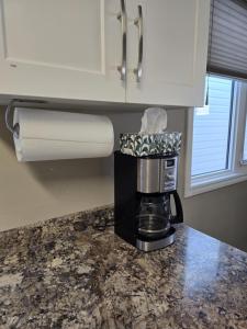 a coffee maker sitting on a counter in a kitchen at Like Home in Regina +7 photos
