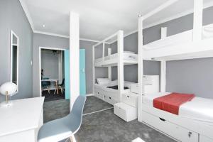 a bedroom with white bunk beds and a desk at CBD City views on 61 wale street by M&B in Cape Town