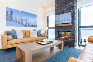 a living room with a couch and a fireplace at The View - Luxury Penthouse Condo in Revelstoke