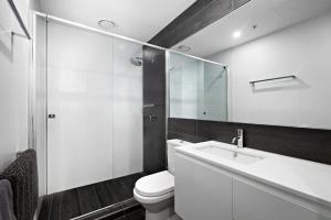 a bathroom with a toilet and a sink and a mirror at A tale awaits - just steps from trendy cafés and lively bars in Melbourne