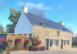 a brick house with flowers in front of it at Le Tigîte B&B entrée privée-petit déj-linge inclus in Allaire