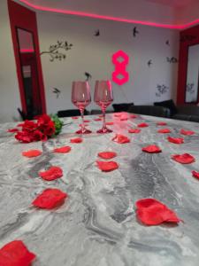 a table with red roses and wine glasses on it at Aura - 8ight Havens in Folkestone