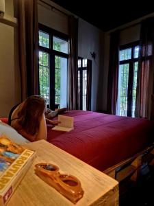 a woman laying on a bed in a room with windows at Hostel Boutique Merced 88 in Santiago