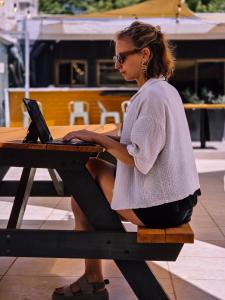 a woman sitting at a picnic table with a laptop at Hostel Boutique Merced 88 in Santiago
