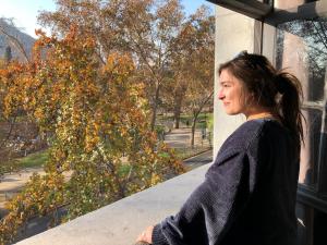 a woman standing on a ledge looking out of a window at Hostel Boutique Merced 88 in Santiago +119 photos