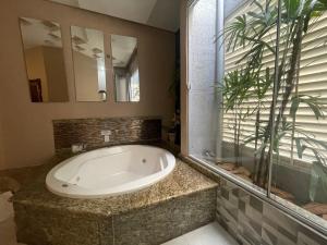 a bath tub in a bathroom with a mirror at Motel Sedución (Adults only) in Cascavel