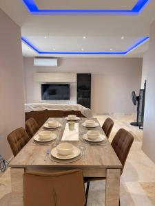 a dining room with a large wooden table and chairs at Panoramic View Penthouse With Dual Terraces in Xagħra