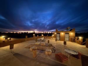 a rooftop patio with tables and chairs at night at Dar Talhaya in Oulad Driss